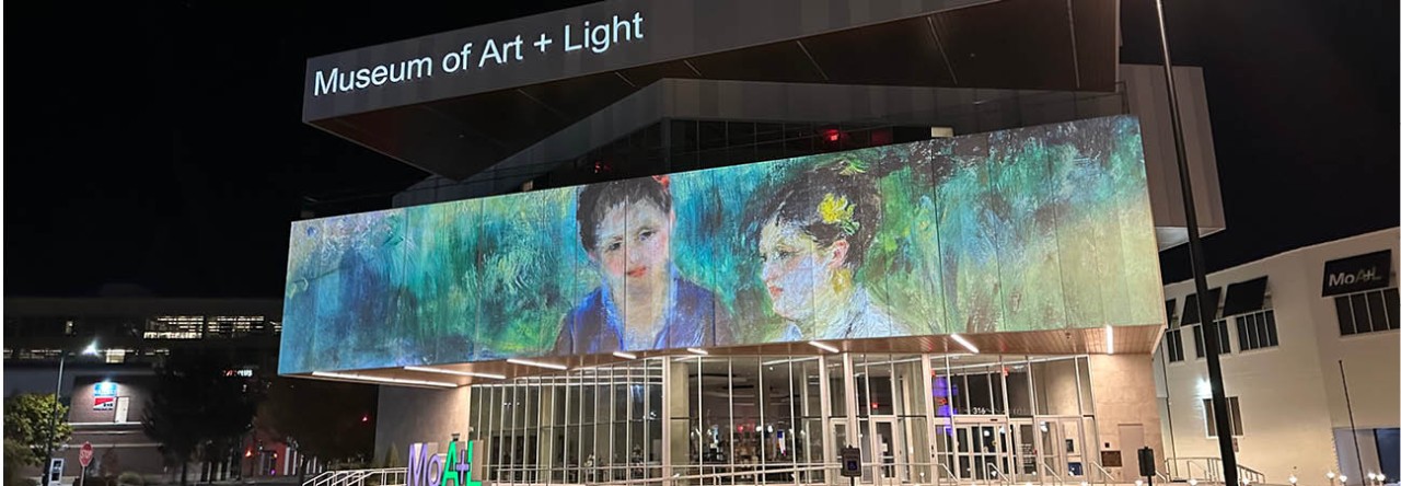 exterior of Museum of Art and Light in Manhattan, KS lit up at night